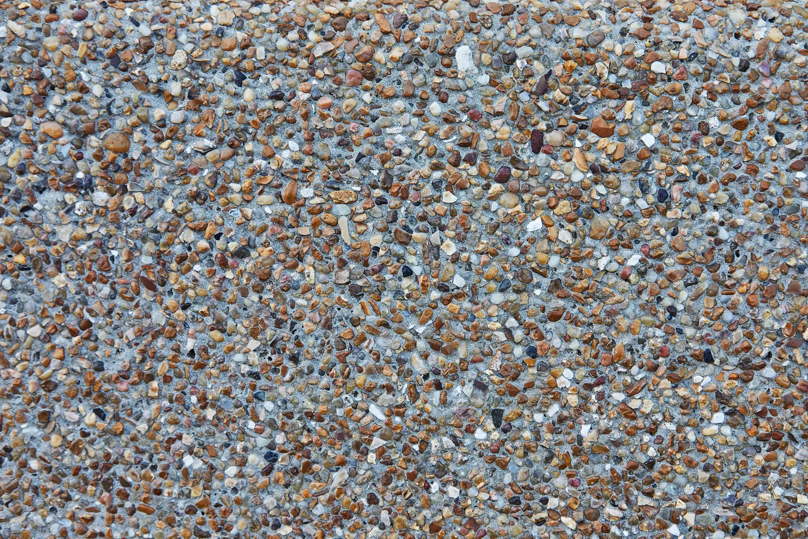 Close-up of exposed aggregate concrete with a tan pebble blend
